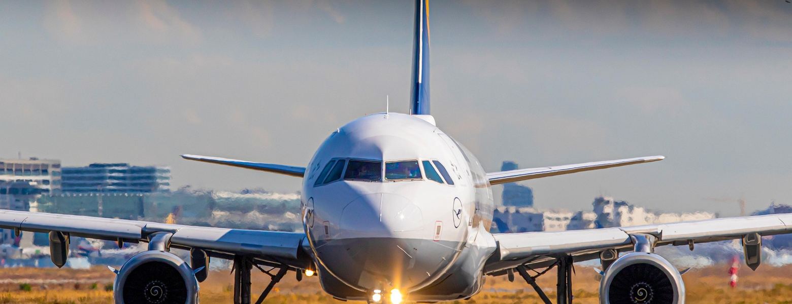 An airliner head-on as it taxis along a runway