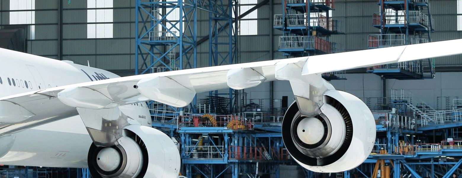 The wing and engines of an aircraft under maintenance in a hangar