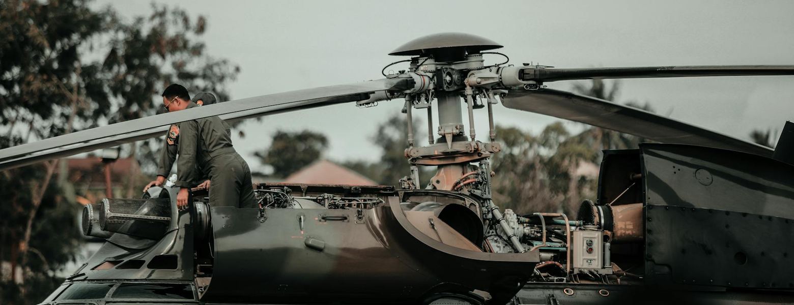 A military helicopter on the ground with crew in the cockpit
