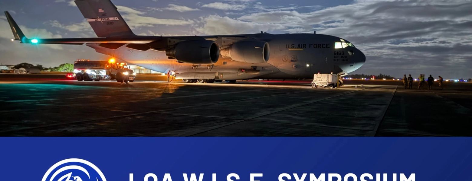 An LOA W.I.S.E. Symposium banner, “logistics: the decisive advantage”, beneath a military transport aircraft on the ramp