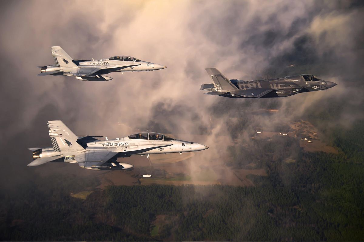 Military jets flying in formation through cloud