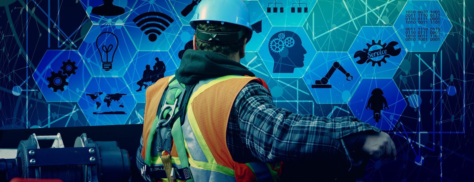 A worker in a hard hat and hi-vis vest facing a wall of hexagonal digital icons