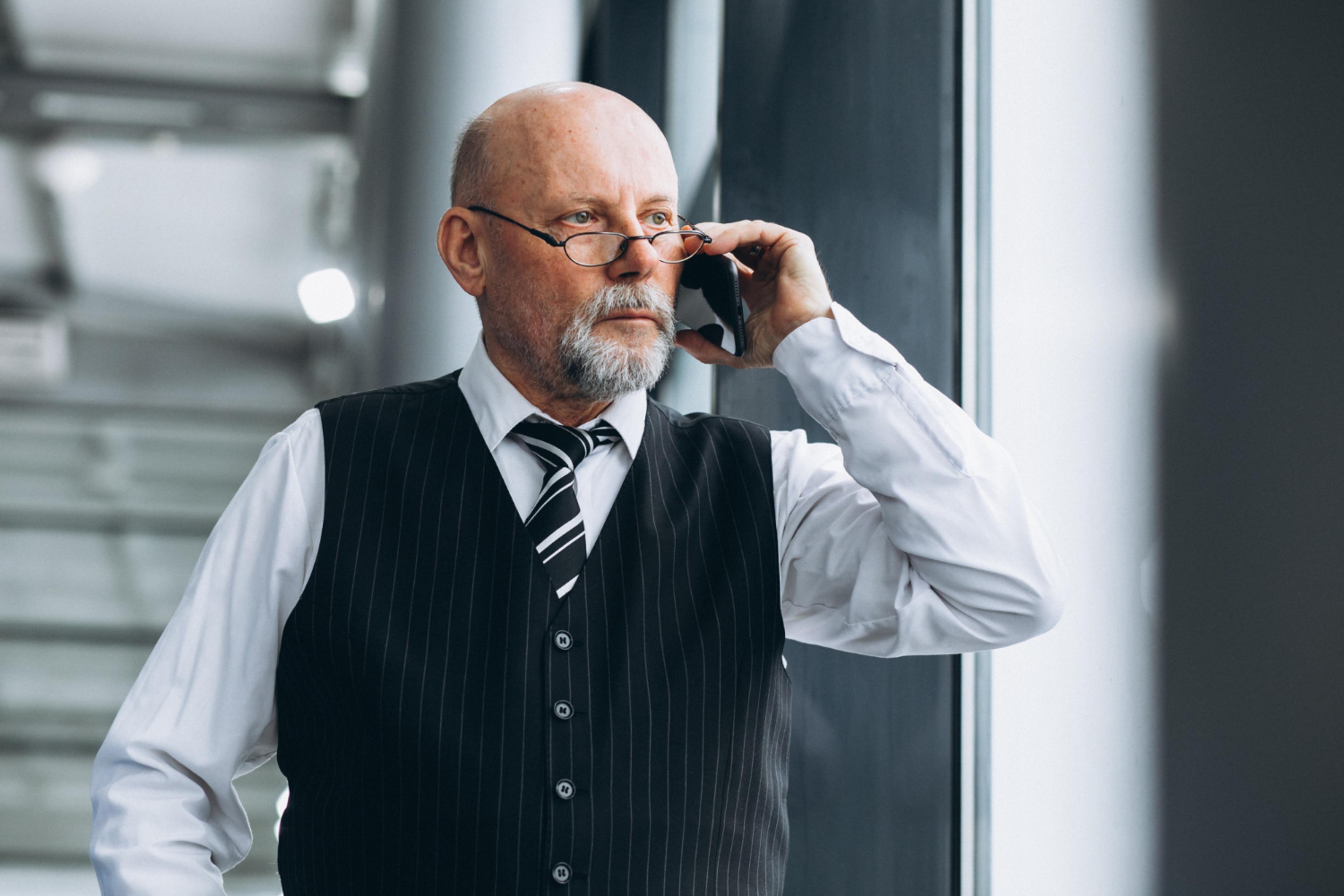 Eldre mann som snakker i telefonen.