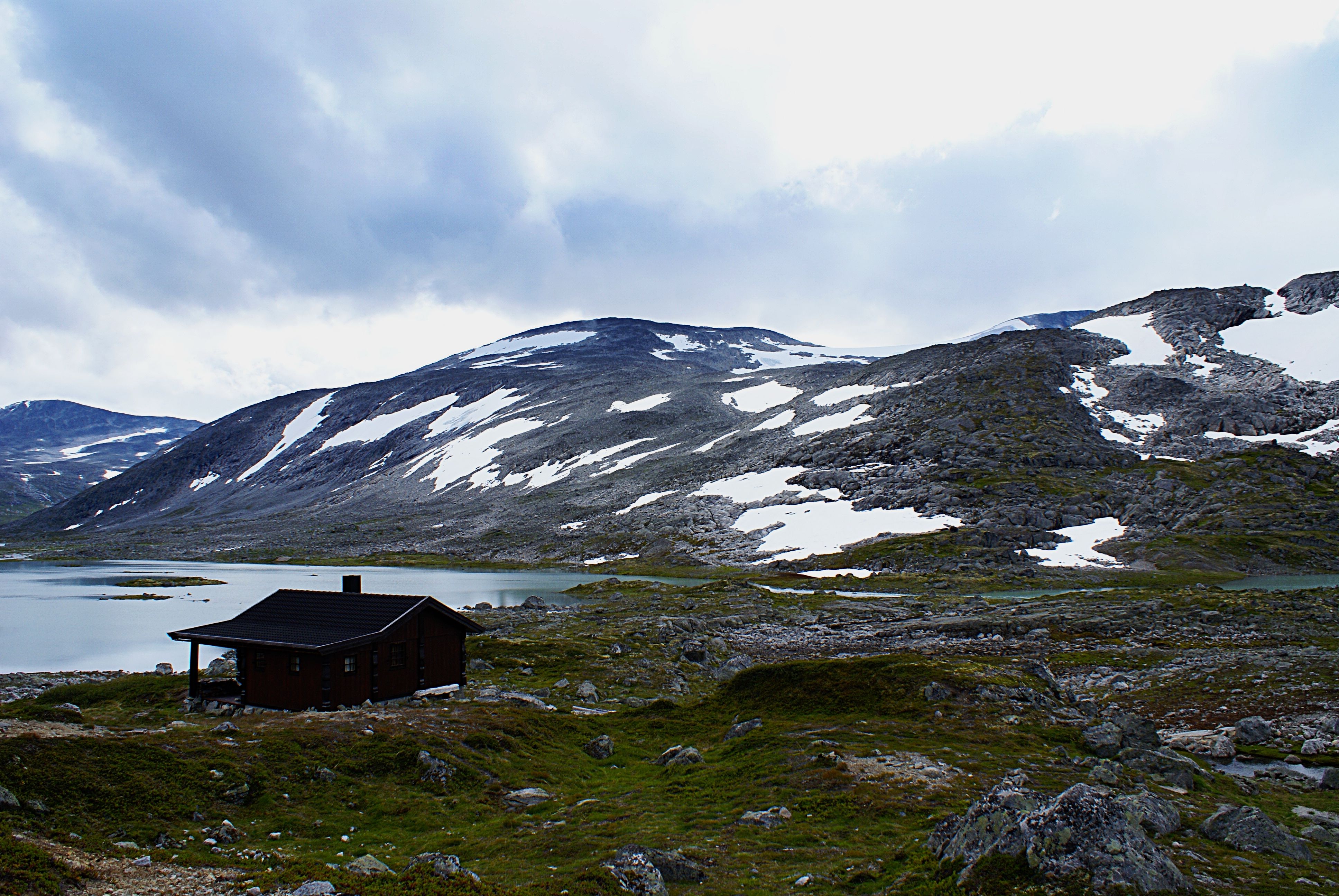 Bilde fra fjellet i Norge med en hytte i bakgrunnen. Overskyet vær