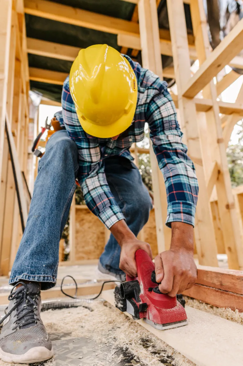 Tømrer som kutter en planke