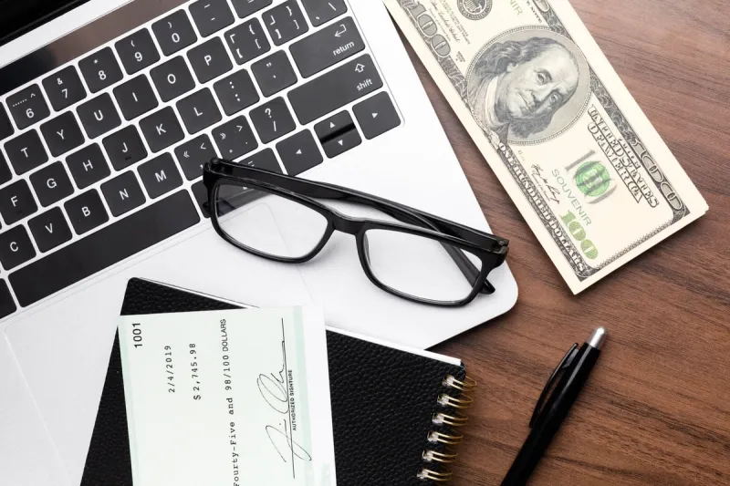 Mac penger og briller som sympoliserer pris på tjeneste