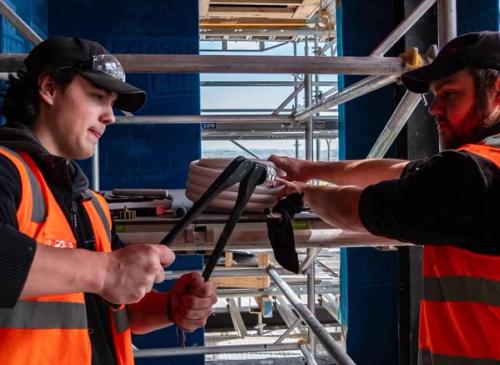 Mechanical Building Services apprentices working with insulated pipework on a commercial building site during workplace-based training
