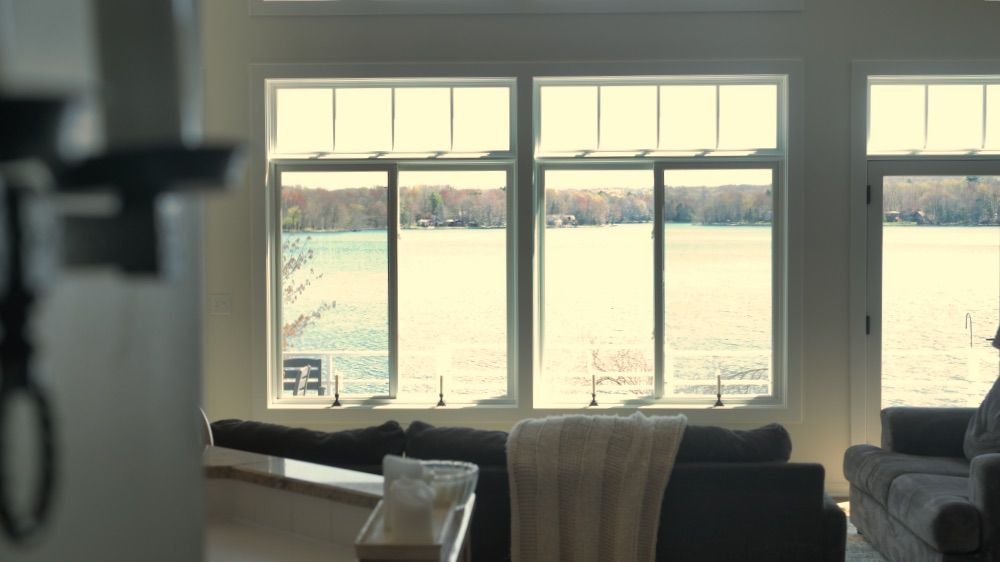 Living area with a wall of windows overlooking the lake