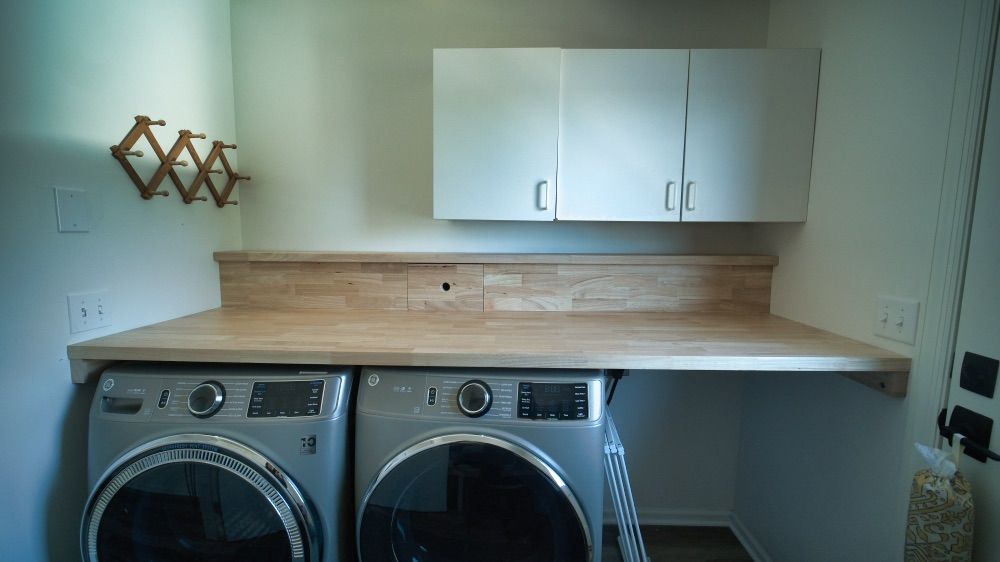 Renovated laundry room with custom cabinetry and a butcher-block counter