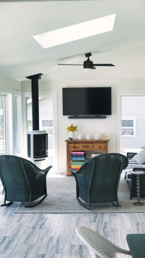 Cozy sitting area with a wood stove and skylight beneath a vaulted ceiling