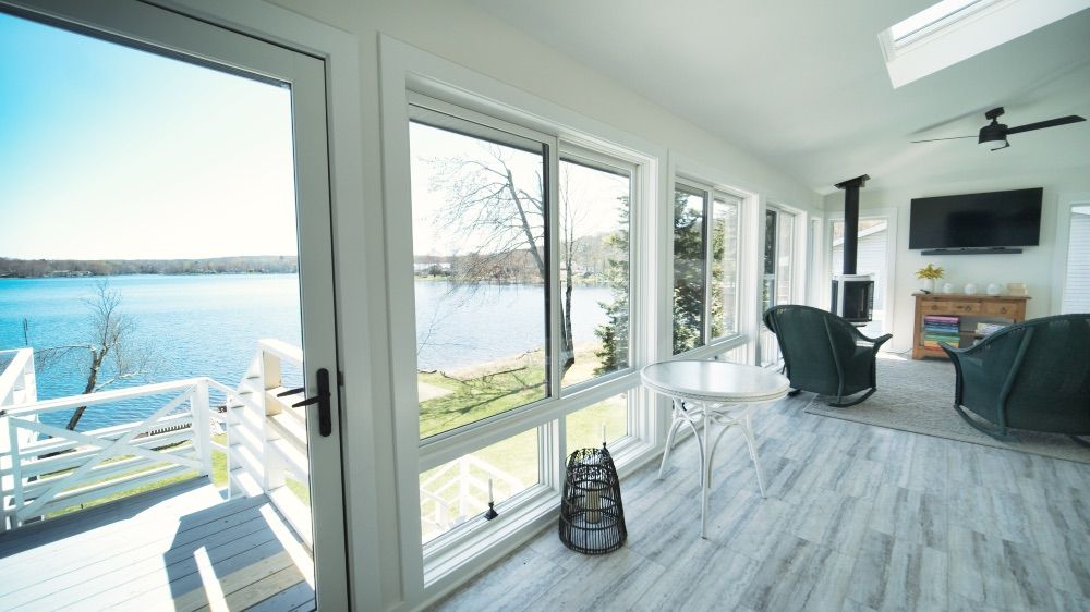 Sunroom dining area with glass doors leading out to the lakeside deck