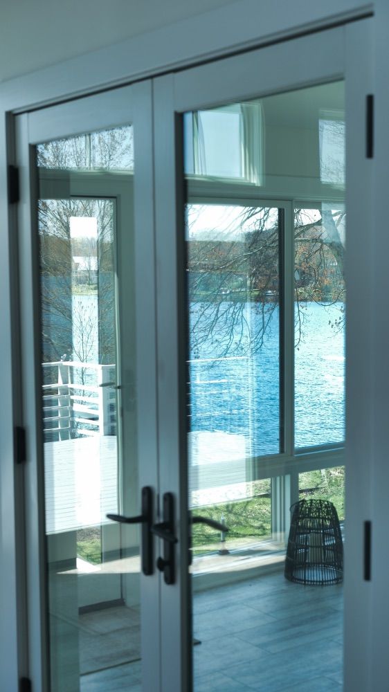 French doors opening onto the deck with a view across the water