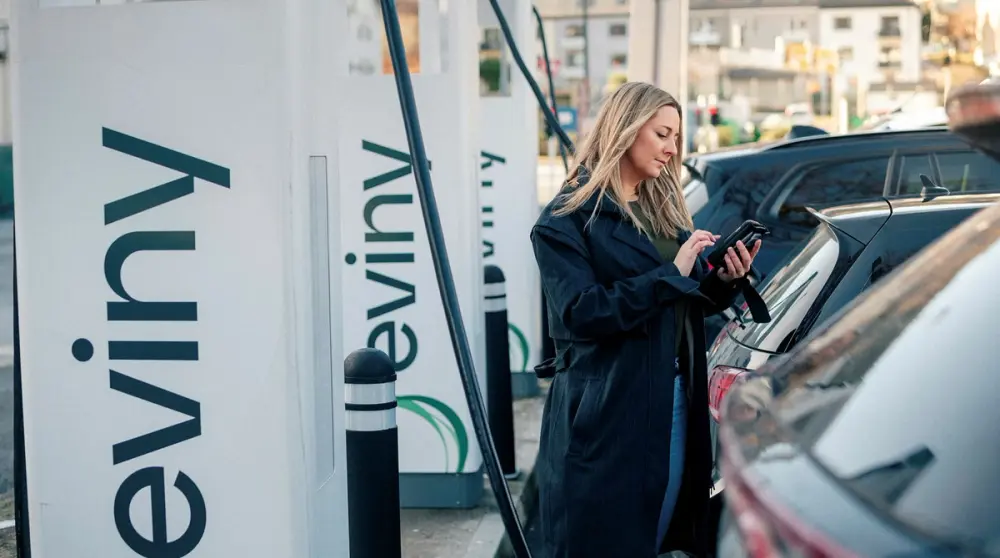 Elbilist lader bilen på en av Eviny sine ladestasjoner