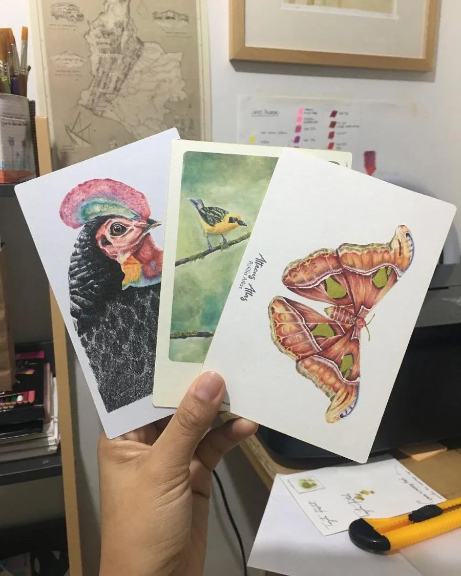 Postal ilustrada sostenida en la mano, en el taller