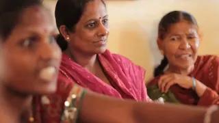 Close up photo of 3 women attending an SHG meeting  
