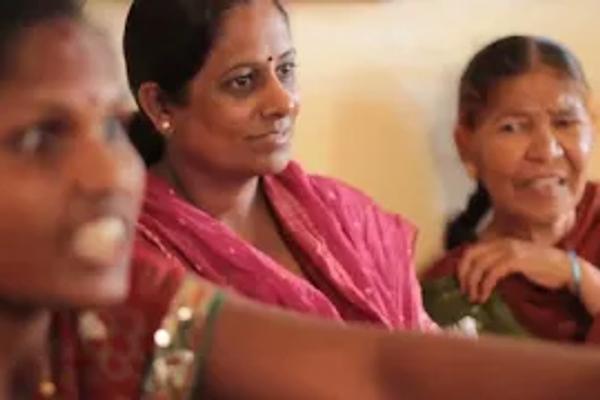 Close up photo of 3 women attending an SHG meeting