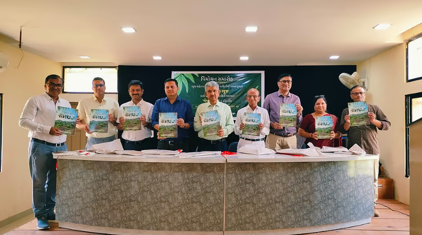 9 people including HIC team and others standing holding the book 