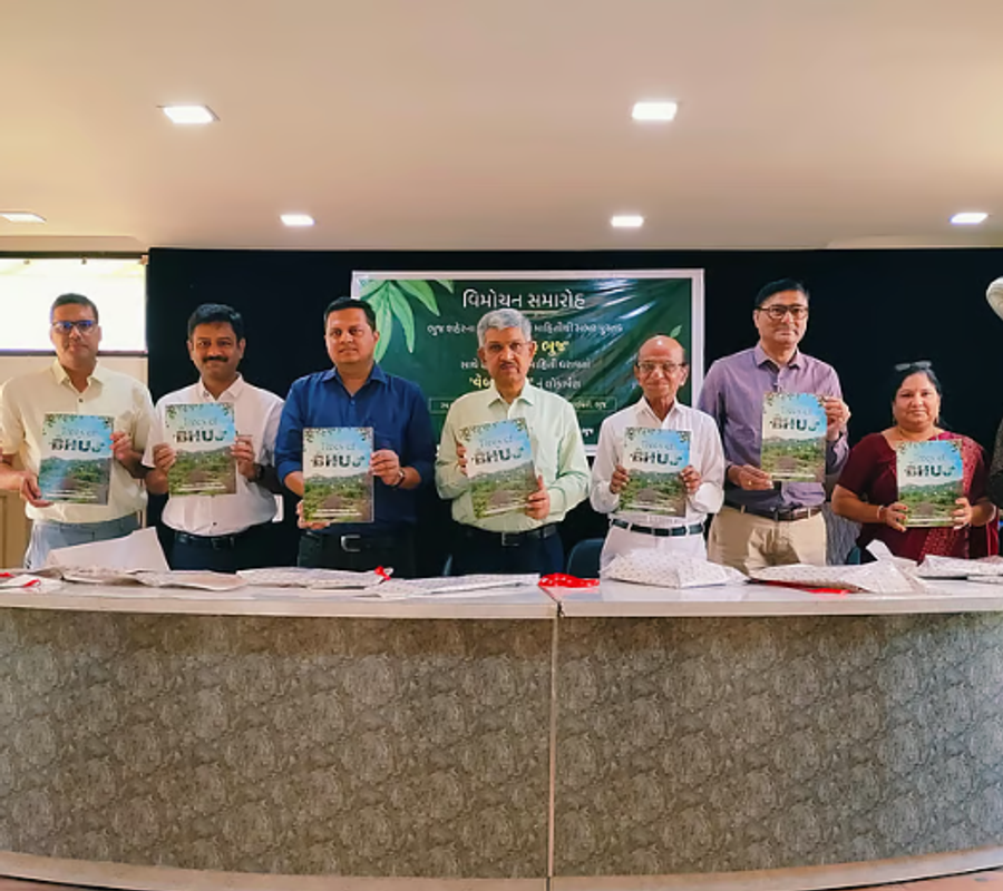 9 people including HIC team and others standing holding the book