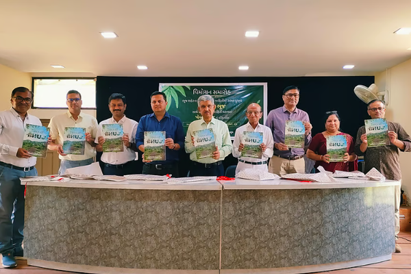 9 people including HIC team and others standing holding the book