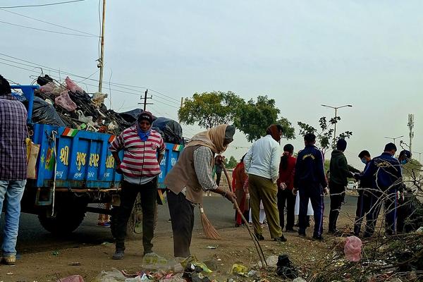 People cleaning a road side