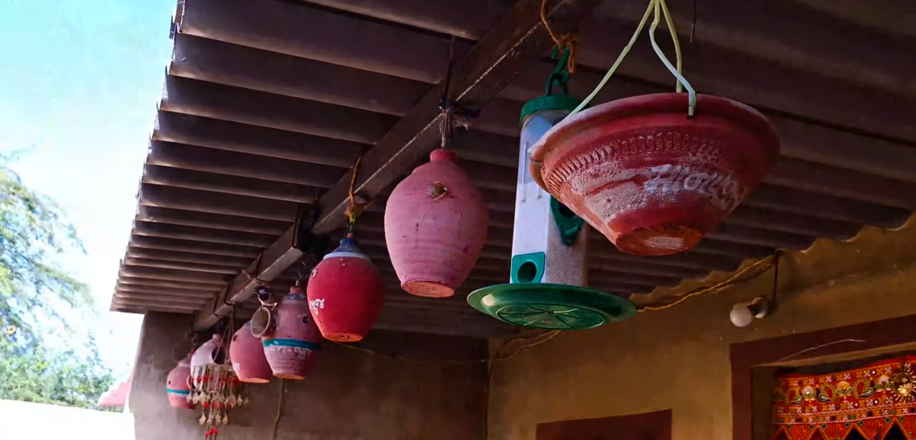 Painted containers are creatively reused as hangings and decorations in front of the house.