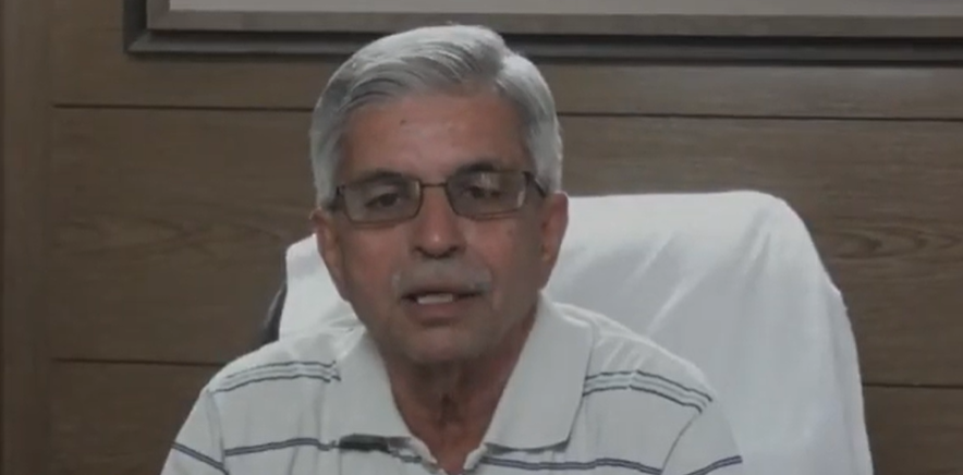 Close up shot of a man, wearing white collar t shirt, speaking.
