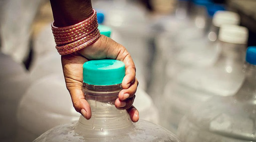 A close up photo of hands holding a water can. 