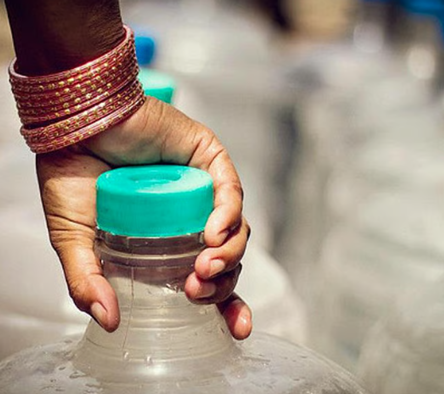 A close up photo of hands holding a water can.