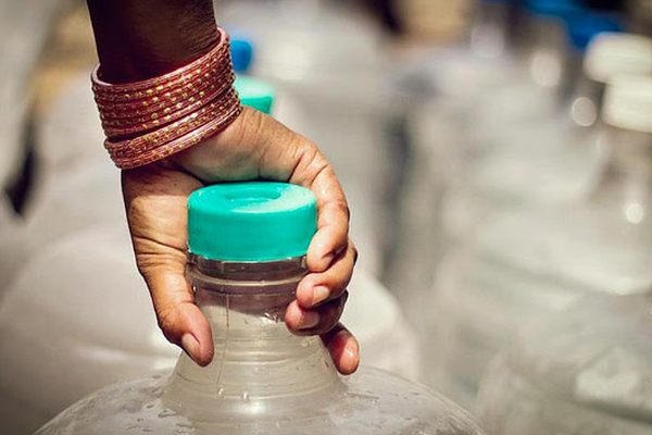 A close up photo of hands holding a water can.