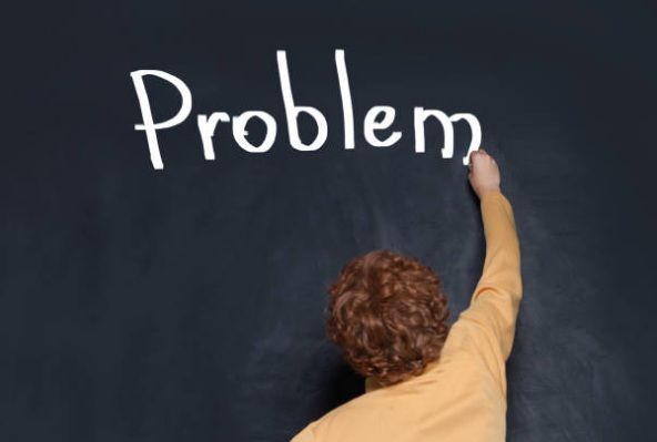 Student writing the word ‘problem’ on a board, symbolising tackling the hardest subject first in their study routine
