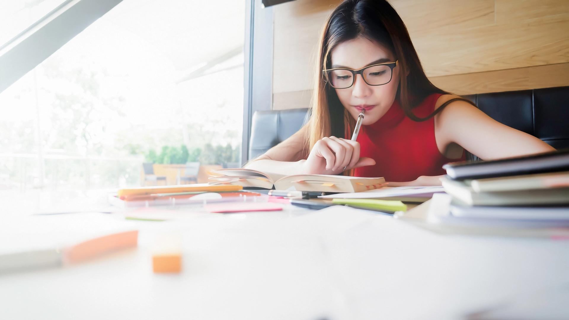 Secondary school student using the pomodoro technique for students while revising at a study desk