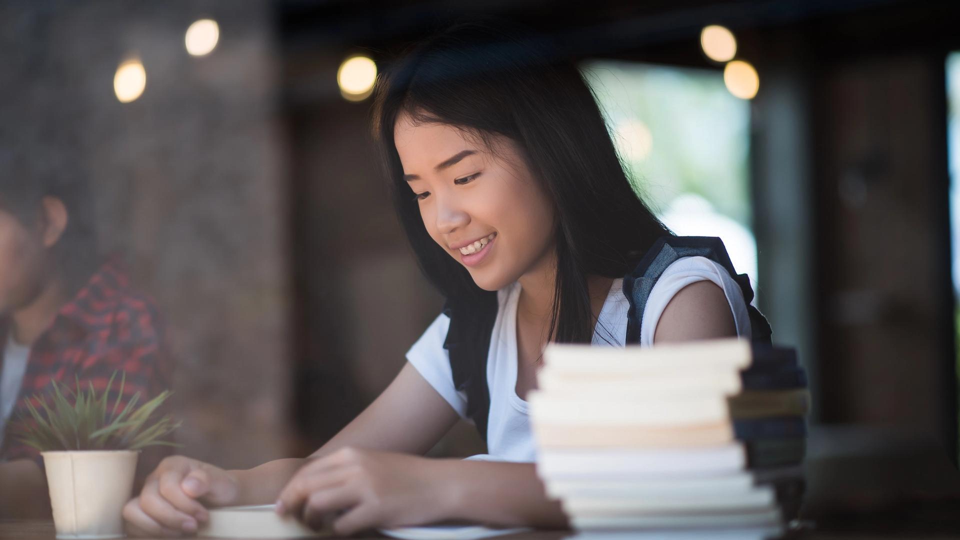 Student planning an O-Level History Elective essay with notes, textbook chapters, and a paragraph outline on the desk