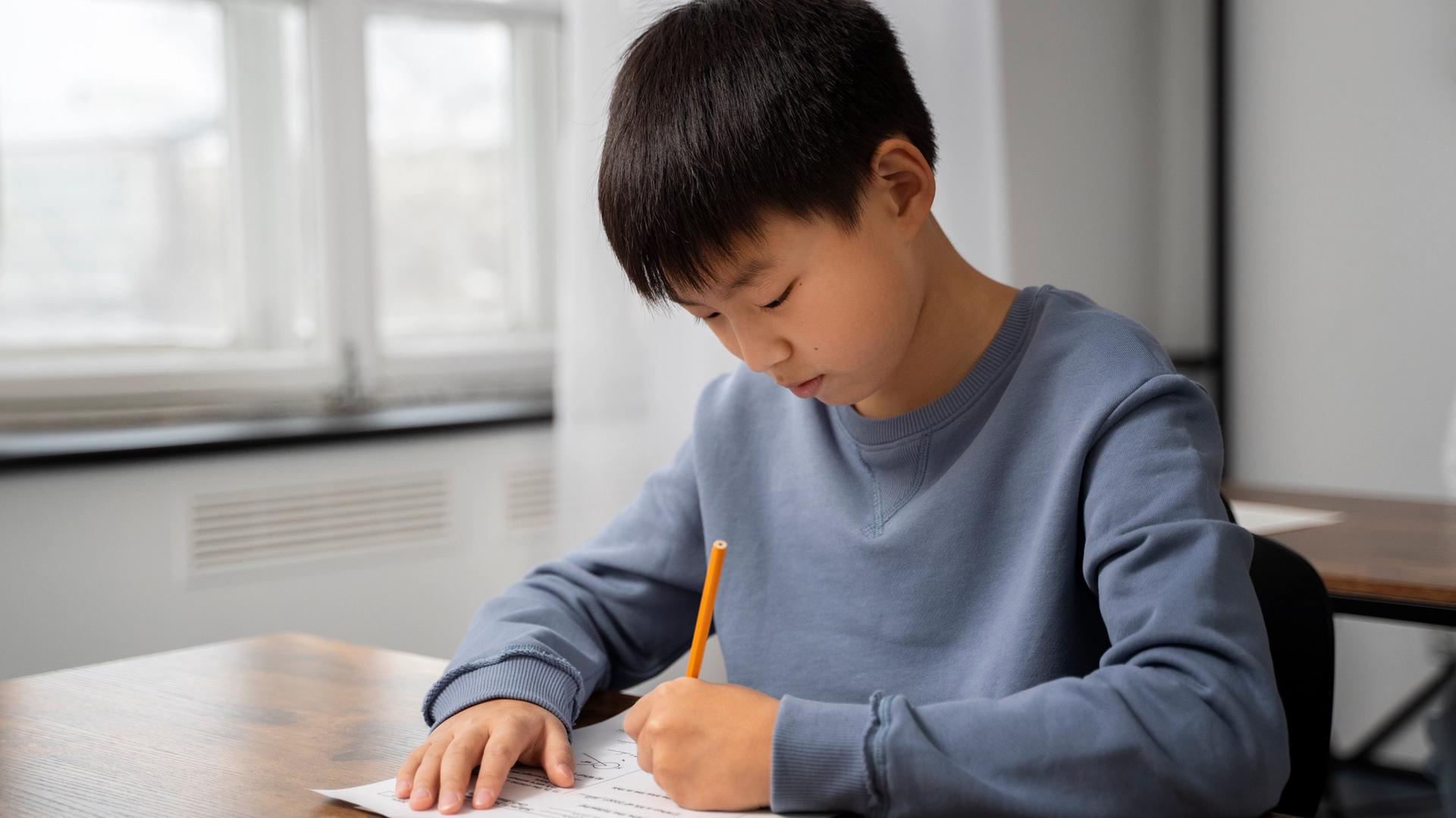 Secondary school student preparing O-Level Chinese composition and oral at a study desk