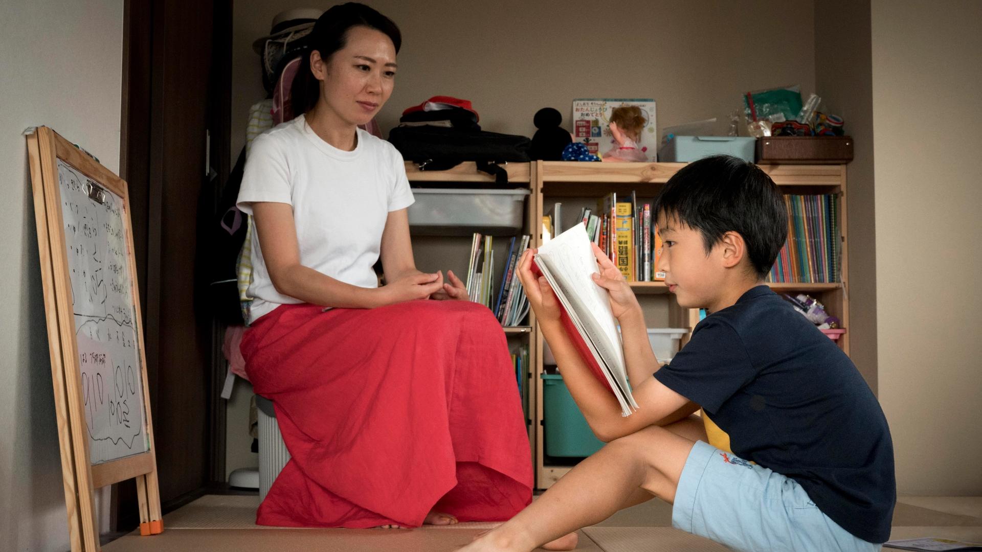 Parent reviewing tutor profiles while child studies at home in Singapore