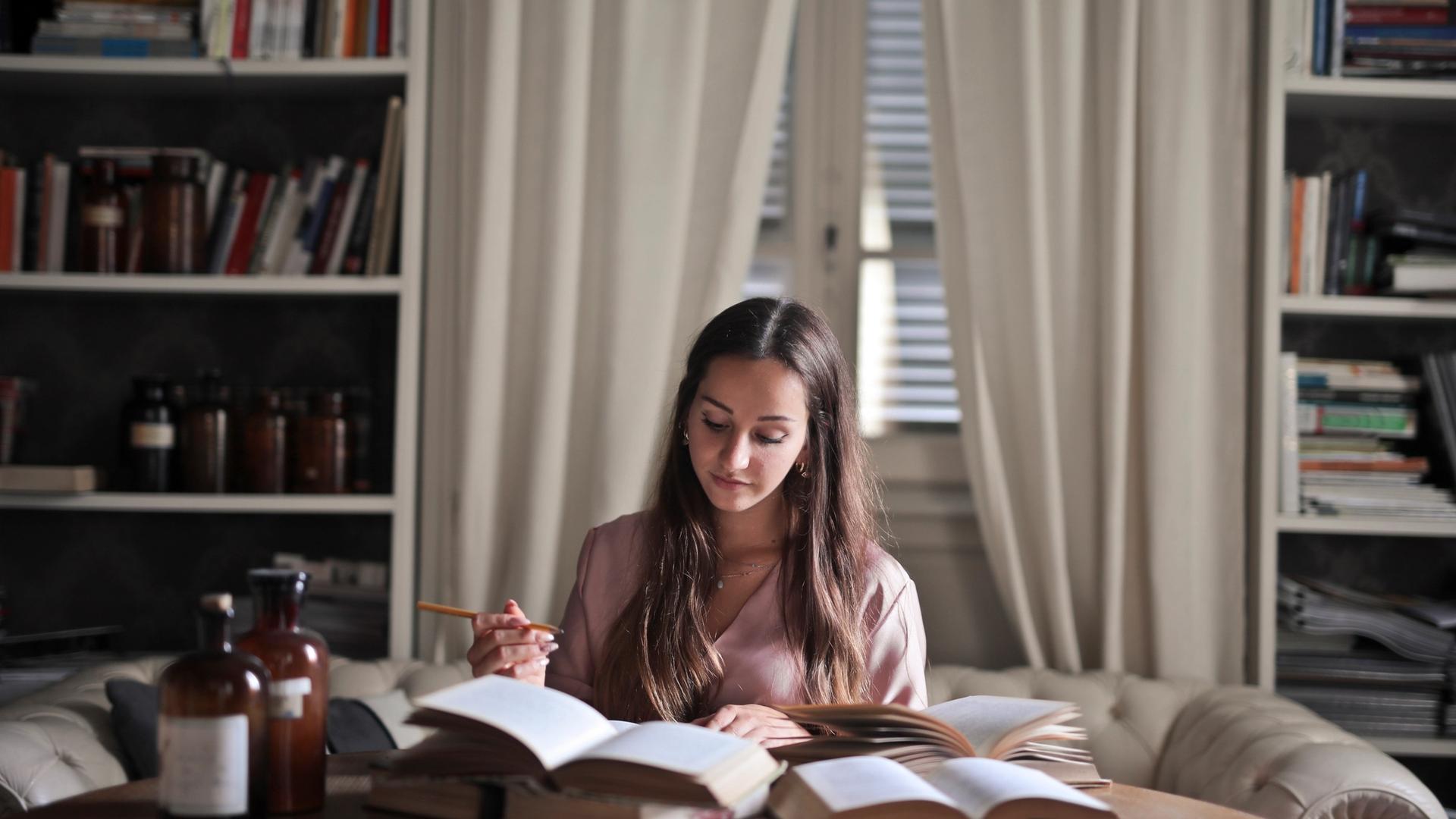 Child studying at a tidy desk in a calm home study environment with organised materials and good lighting