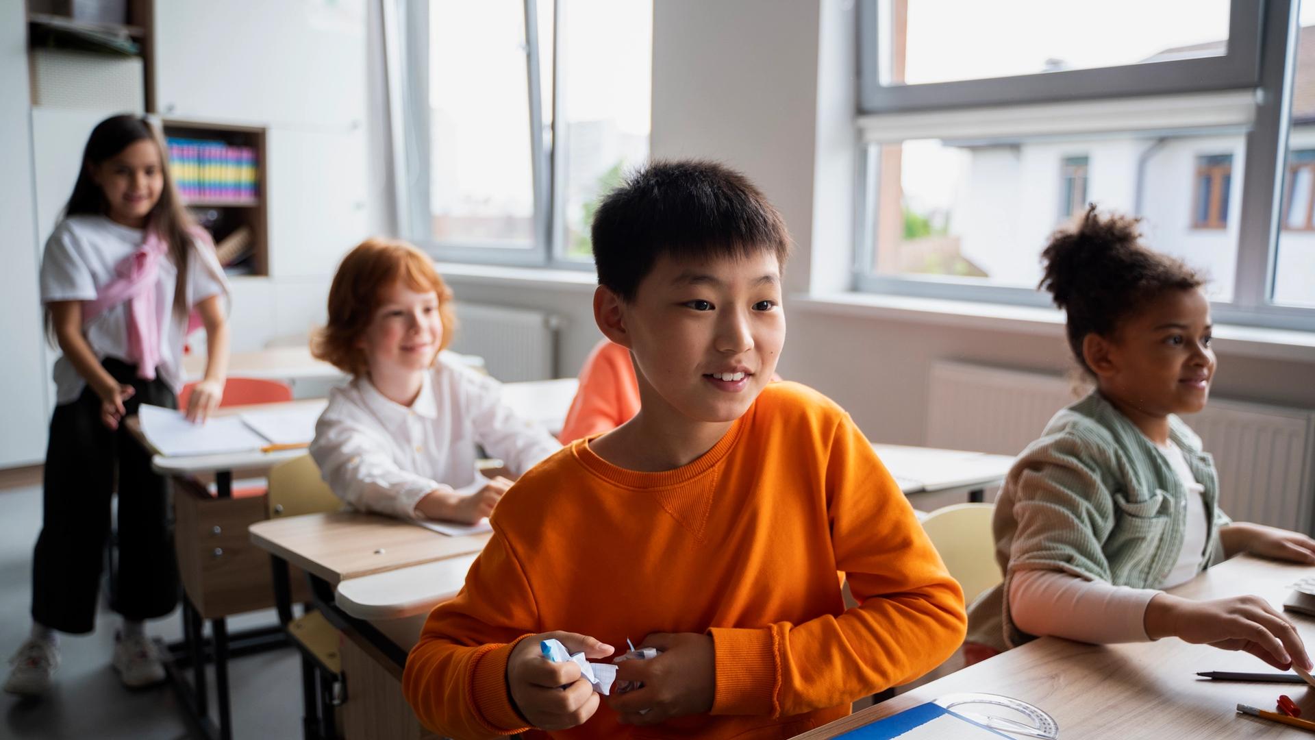 Parent discussing study progress with a tutor who is reviewing organised lesson notes for multiple students