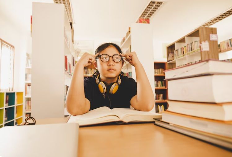Secondary school student feeling stressed while studying in the library, highlighting the challenges of the Sec 3 to Sec 4 transition