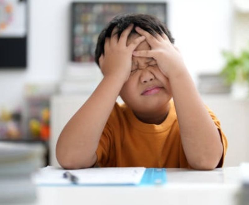 Stressed primary school student struggling with homework at home
