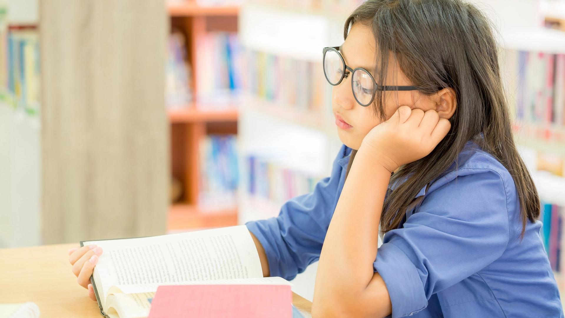 tired student showing child burnout signs while studying at home with books and notes