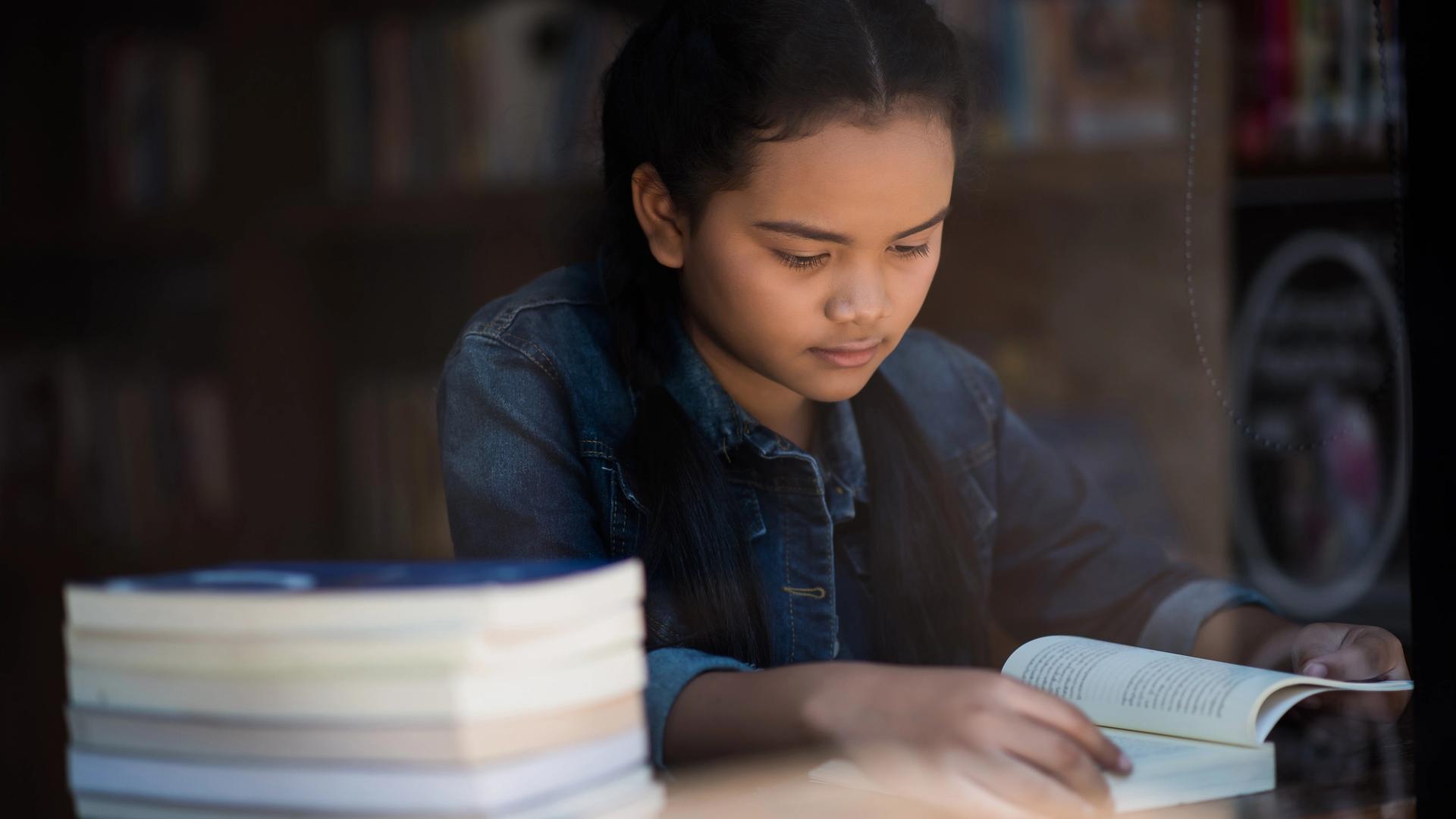 Secondary school student doing o level literature analysis with highlighted text and notes
