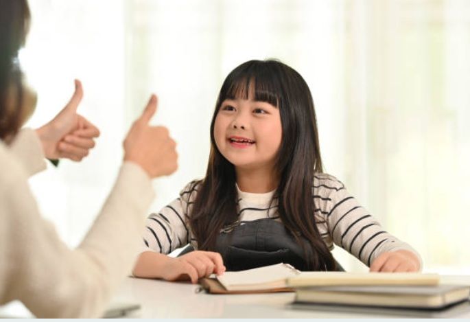 Primary school girl enjoying a positive home tuition session with her tutor in Singapore.