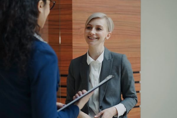 Two women in business attire talking