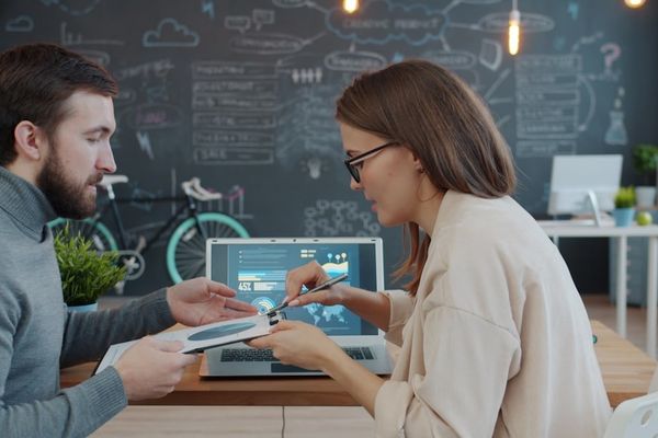 Two colleagues discussing a project at a desk.