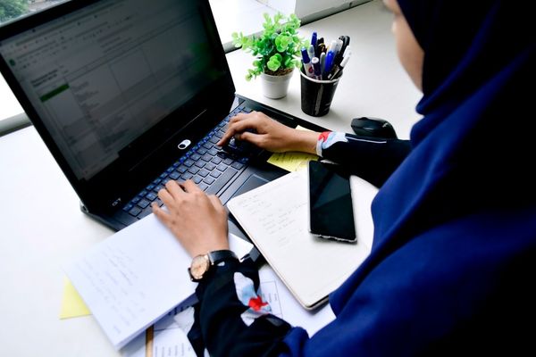person in blue long sleeve shirt using black laptop computer
