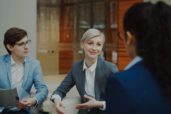 Three people in a business meeting discussing documents