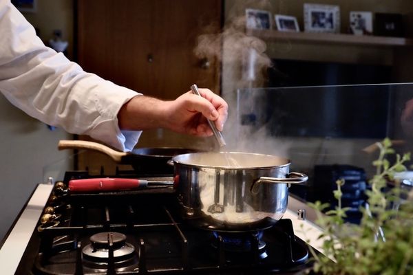 person cooking in stainless steel cooking pot