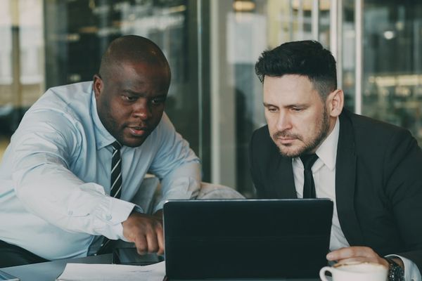 Two men looking at a laptop together