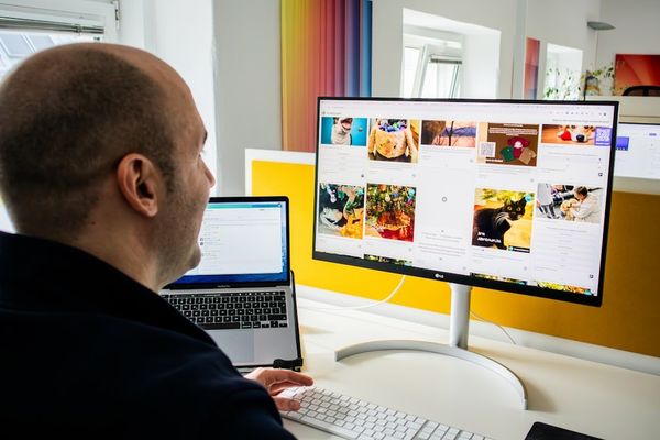 a man sitting in front of a computer monitor