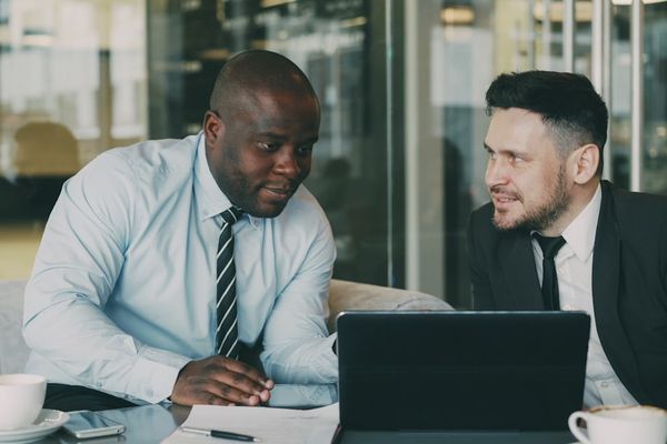 Two businessmen discussing documents at a table.