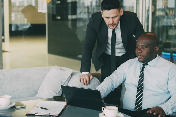 Two businessmen collaborating on a laptop in an office.